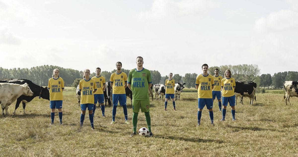 Een beeld uit een promofilmpje van SK Beveren. De tweedeprovincialer speelt in geel-blauwe shirts waarop de slogan 'Drink Melk' prijkt, net zoals het oude Beveren toen dat in 1984 zijn tweede landstitel pakten.