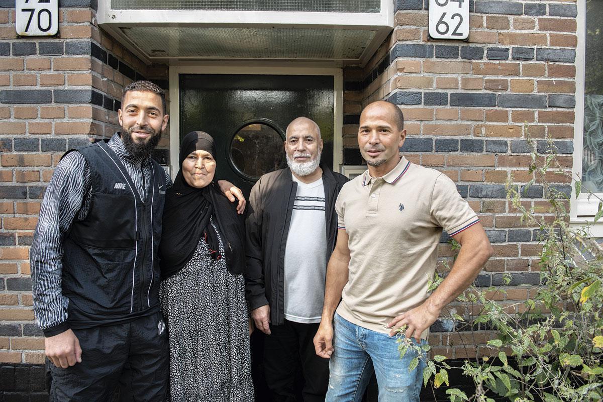 Broers Omar (links) en Mohammed (rechts) poseren samen met moeder Aicha en vader Messoud voor het ouderlijke huis in Amsterdam.