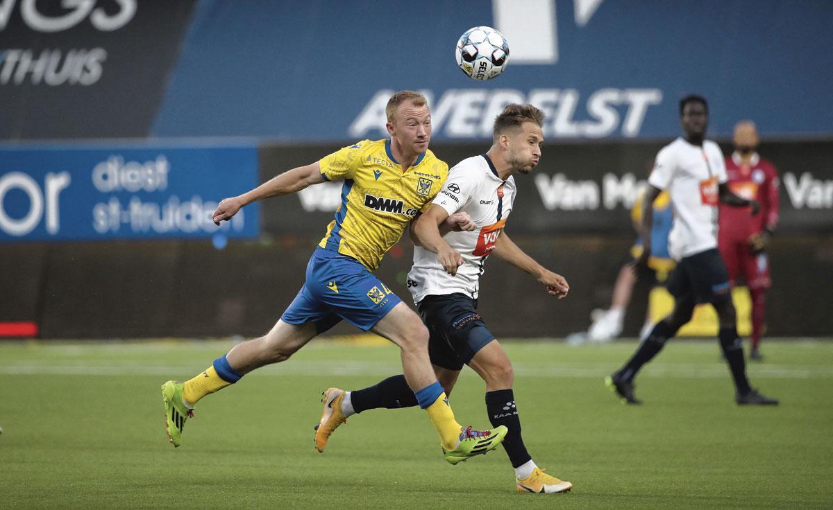 STVV - Gent 2-1 Christian Brüls (l) laat zich gelden in een stevig duel met Andrew Hjulsager. De middenvelder van de Kanaries was alomtegenwoordig en zorgde met een pareltje van een vluchtschot voor de overwinning.