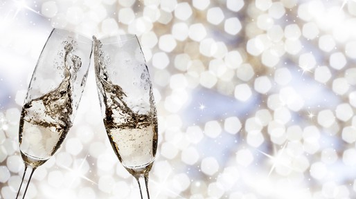 Toasting with champagne glasses on sparkling holiday background