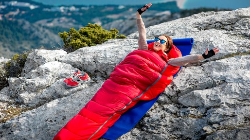 Woman in sleeping bag on the mountain