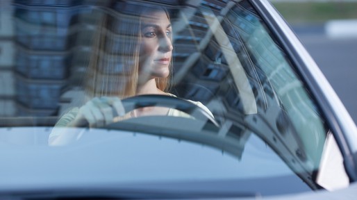 young adult blonde woman driving a car