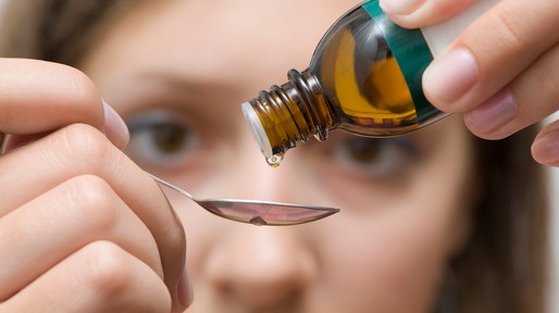 Brown eyed woman trying to correctly dose an herbal medicine