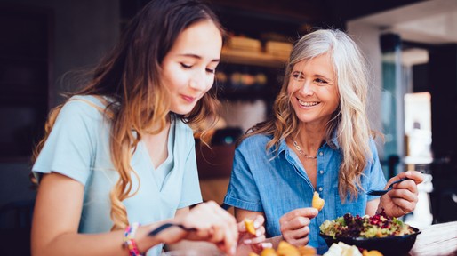 Beautiful senior mother and daughter eating lunch together at restaurant