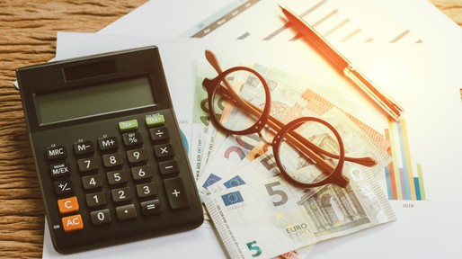 tax-calculation-or-budget-planning-concept-eyeglasses-pen-on-pile-of-picture-id941599740