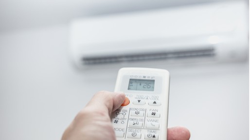 air-conditioner-closeup-hand-with-remote-control-picture-id8670533061